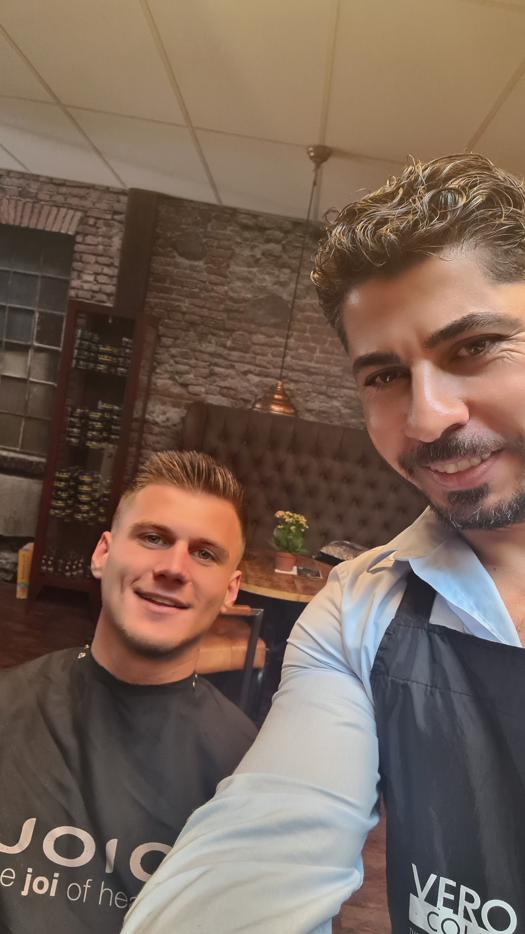 Barber van The Art of Hair met een tevreden klant in de salon