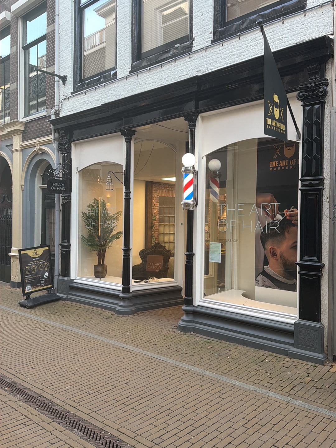 De gevel van The Art of Hair aan de Langendijk met barberpaal