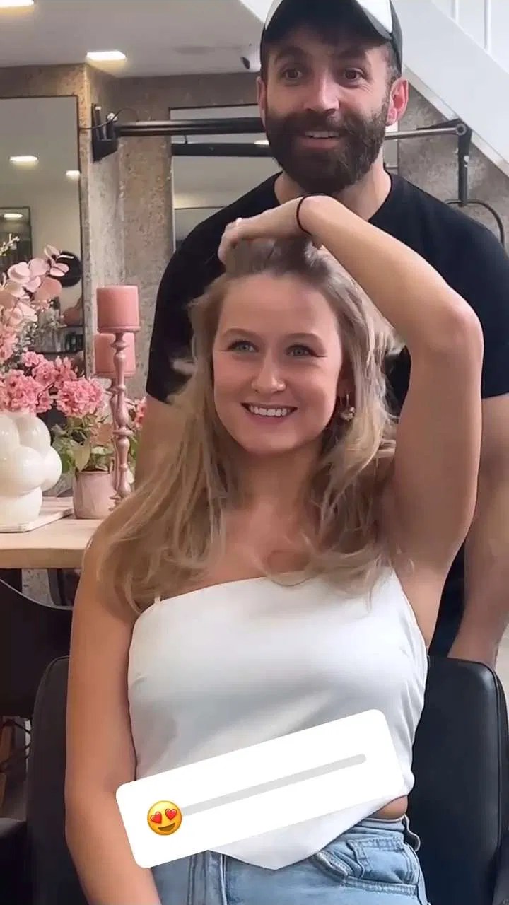 Klant met lange blonde golven en haar stylist